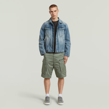 Model wearing relaxed fit Rovic zip shorts with denim jacket and sneakers in green.