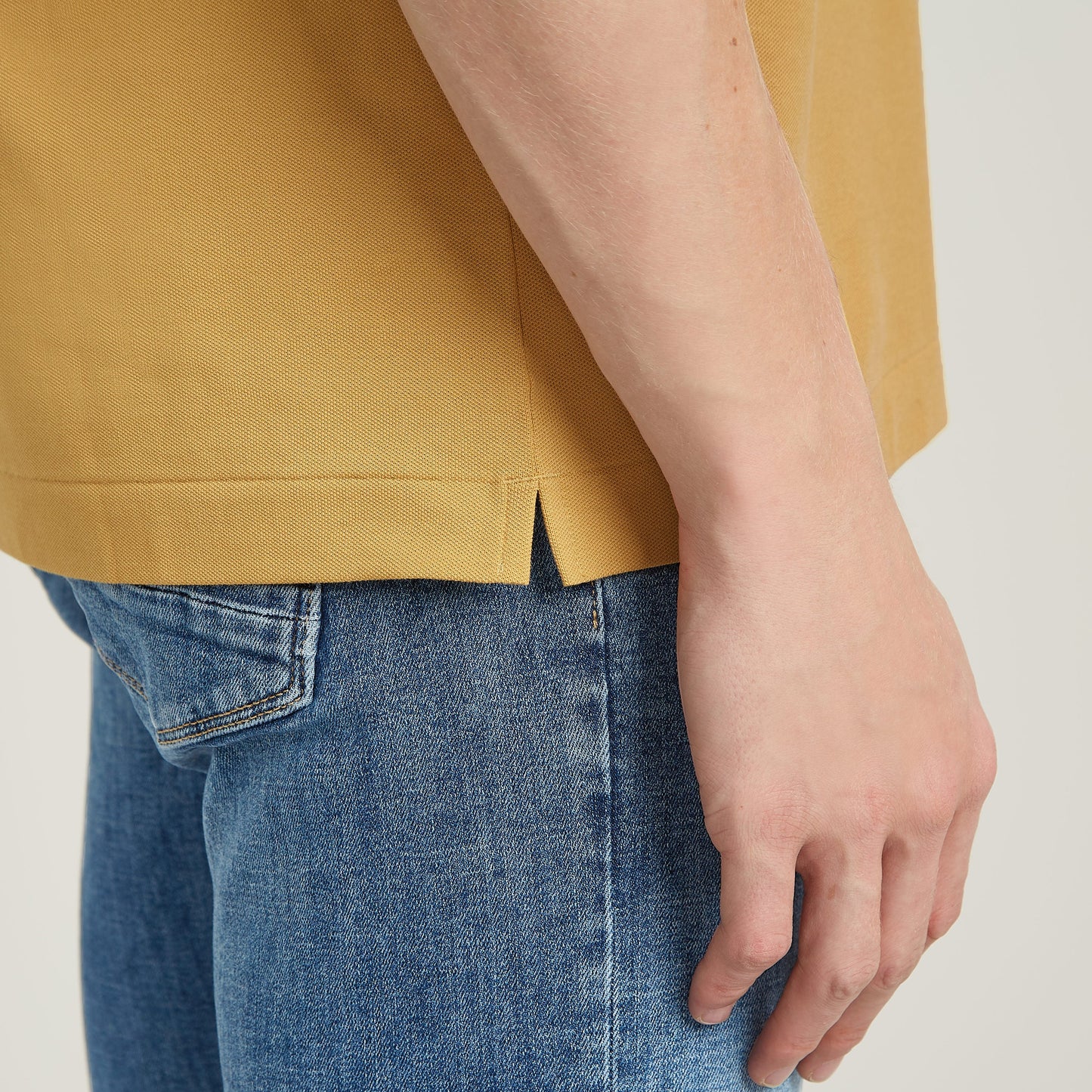 Dunda Slim polo close-up showing side slit and casual fit, highlighting the garment's design and style.