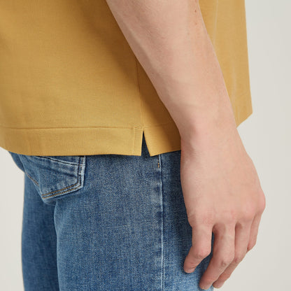 Dunda Slim polo close-up showing side slit and casual fit, highlighting the garment's design and style.