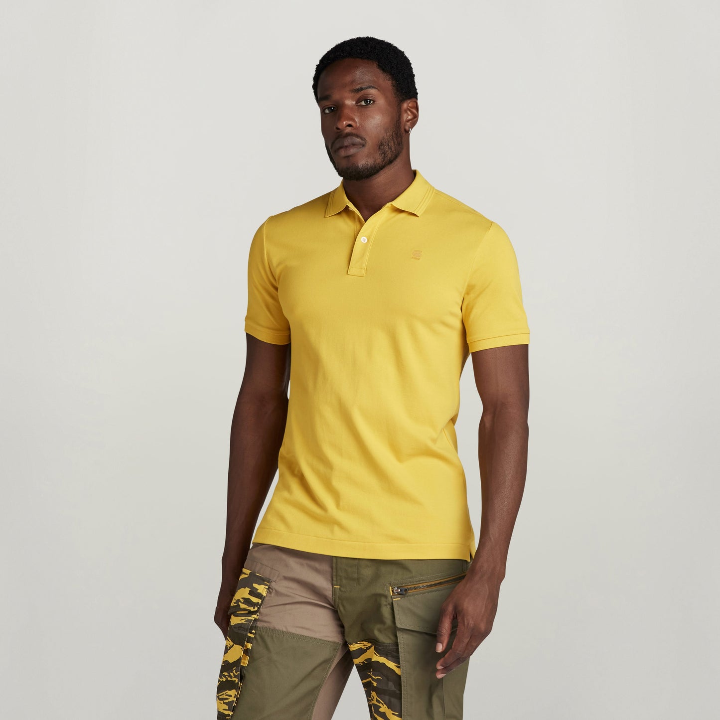 Modelo vistiendo el polo Dunda Slim de color amarillo con cuello acanalado polo slim.