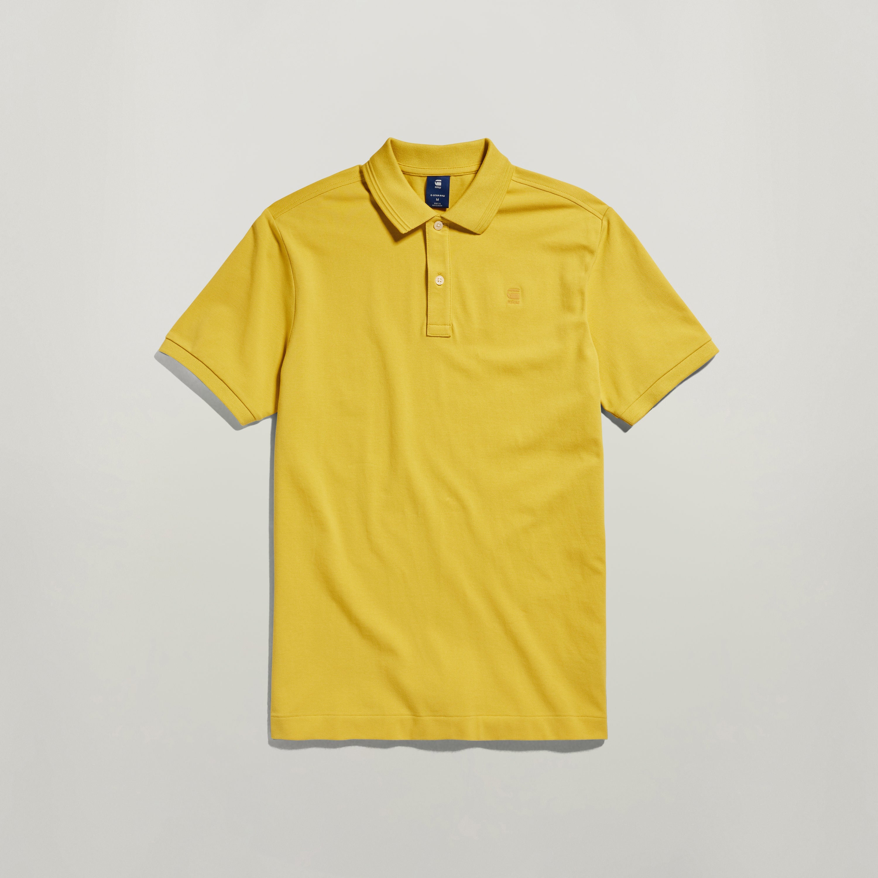 Polo Dunda Slim amarillo con diseño acanalado en el cuello y puños, ideal para mayor libertad de movimiento.