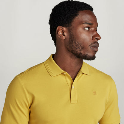 Hombre con polo Dunda Slim amarillo con diseño acanalado, mostrando cuello y puños acanalados.