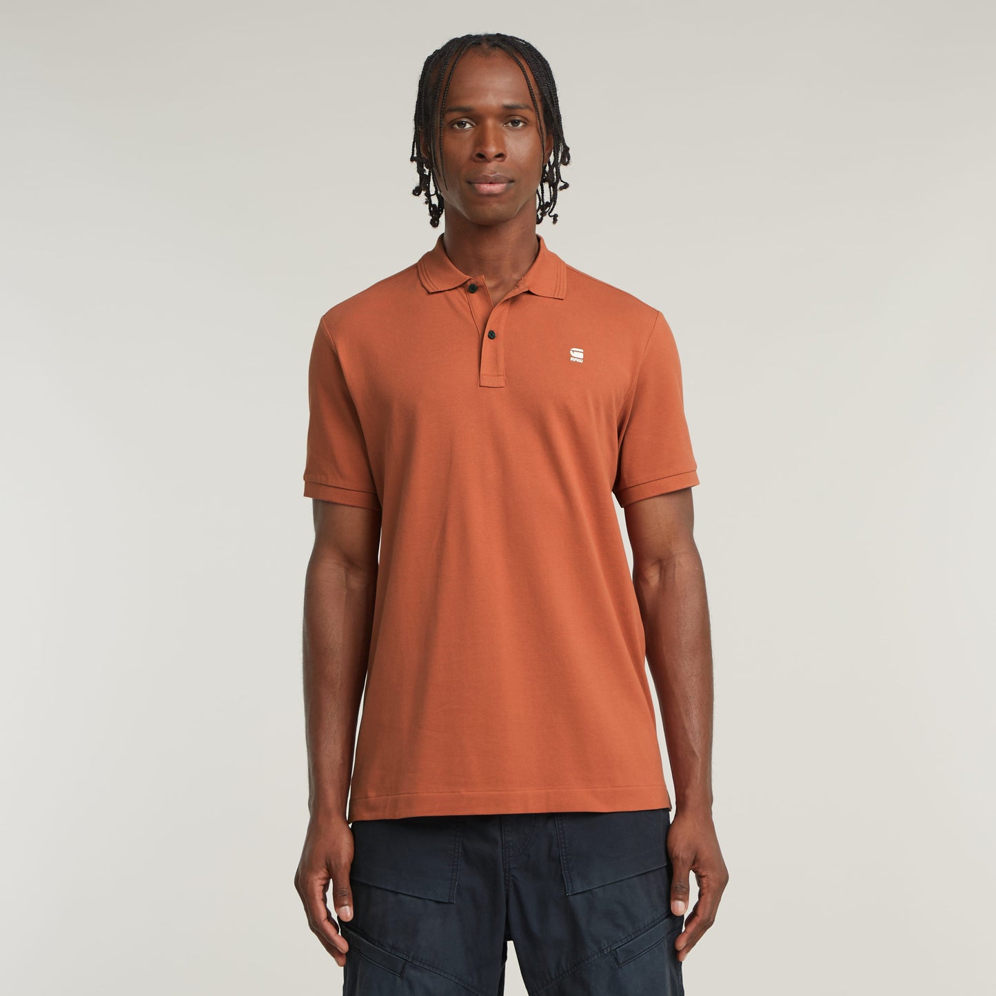 Hombre usando un polo Dunda Slim en color marrón, un slim fit polo shirt, con cuello y mangas acanaladas.