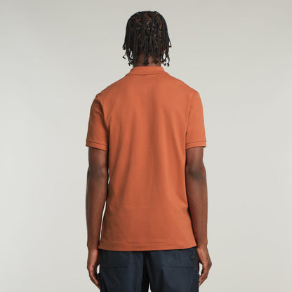 Slim fit polo shirt in orange, showing back view and short sleeves with ribbed details.
