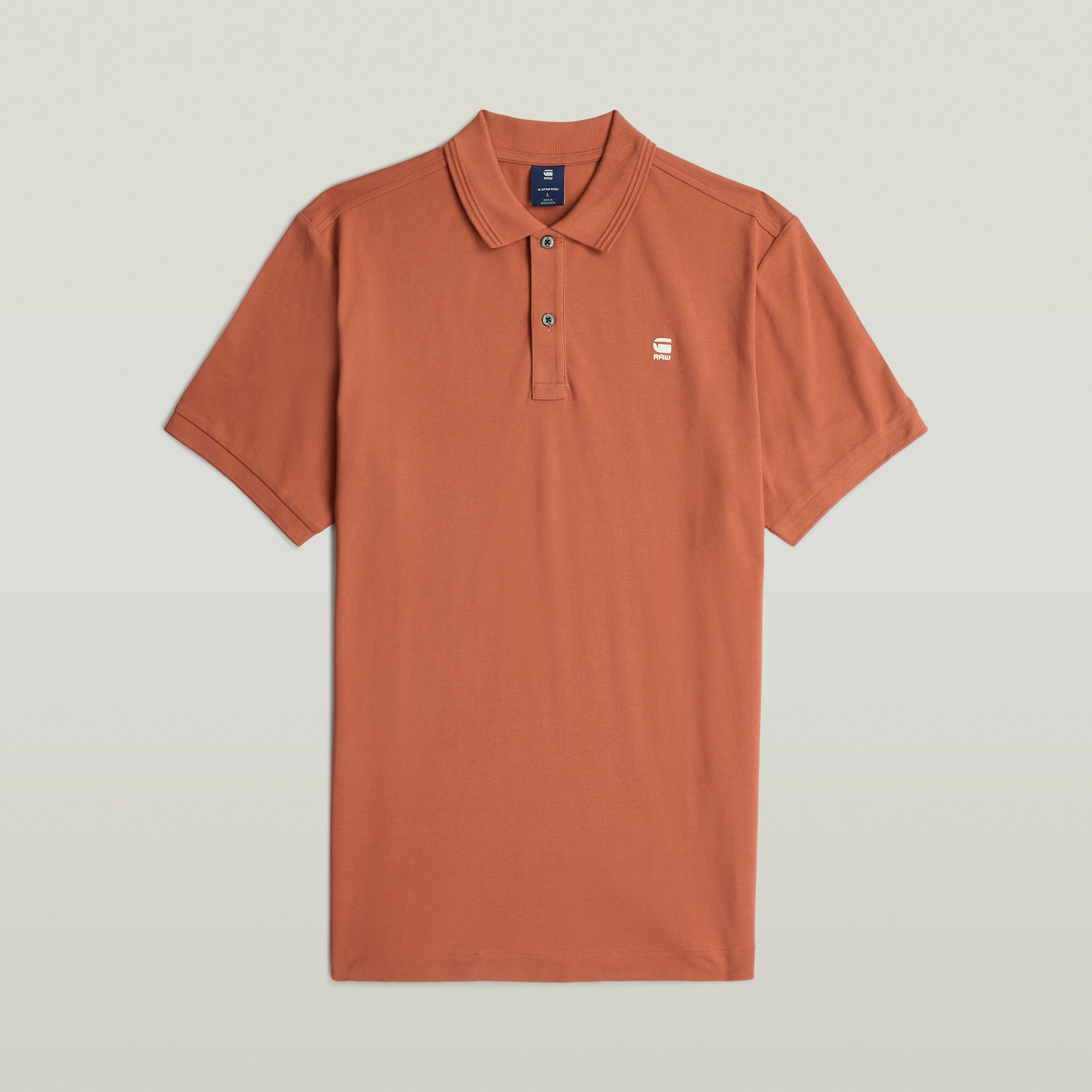 Polo Dunda Slim en color naranja, con diseño acanalado, características de un slim fit polo shirt y bordado en el pecho.