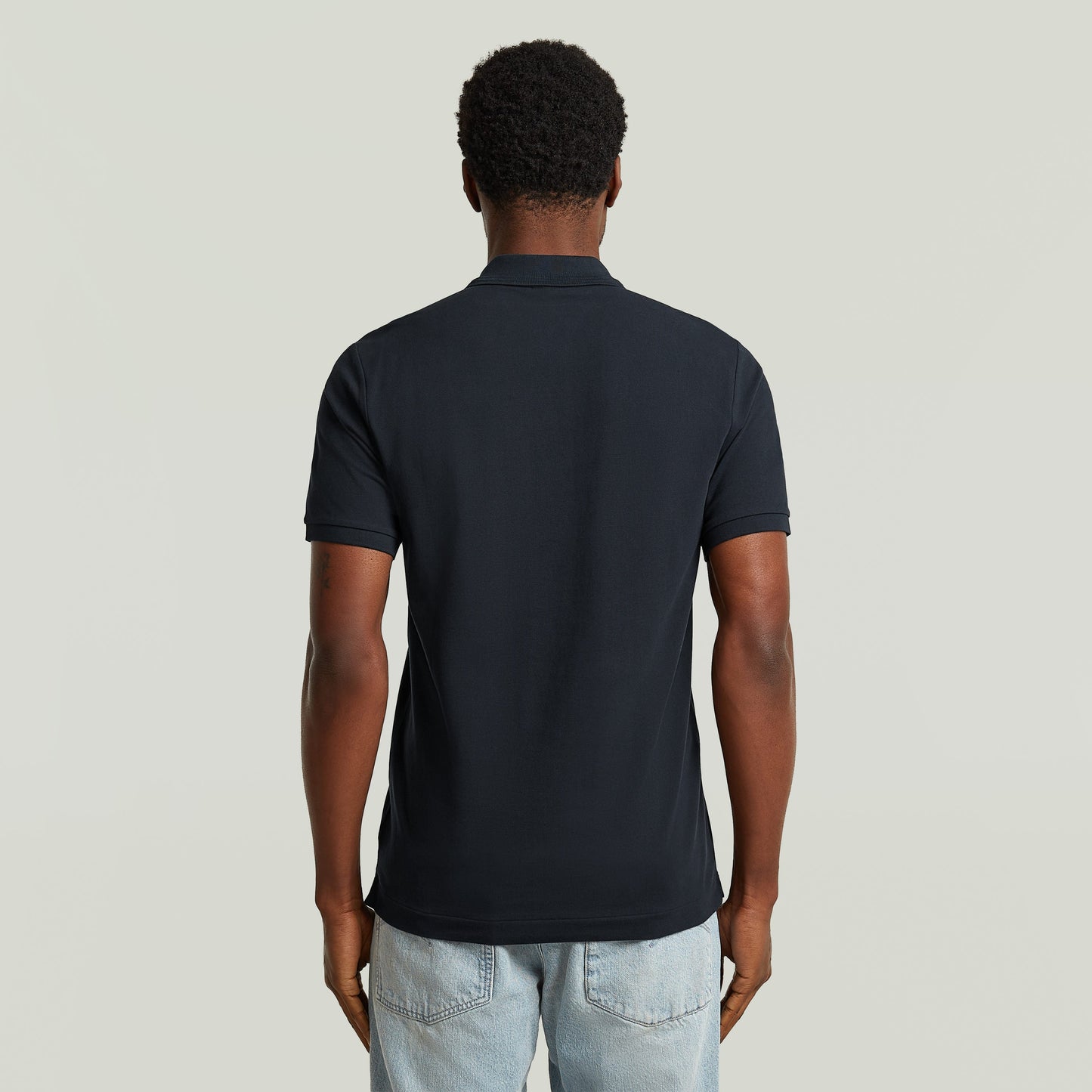 Muestra trasera del polo Dunda Slim, una slim fit polo shirt de color azul oscuro.
