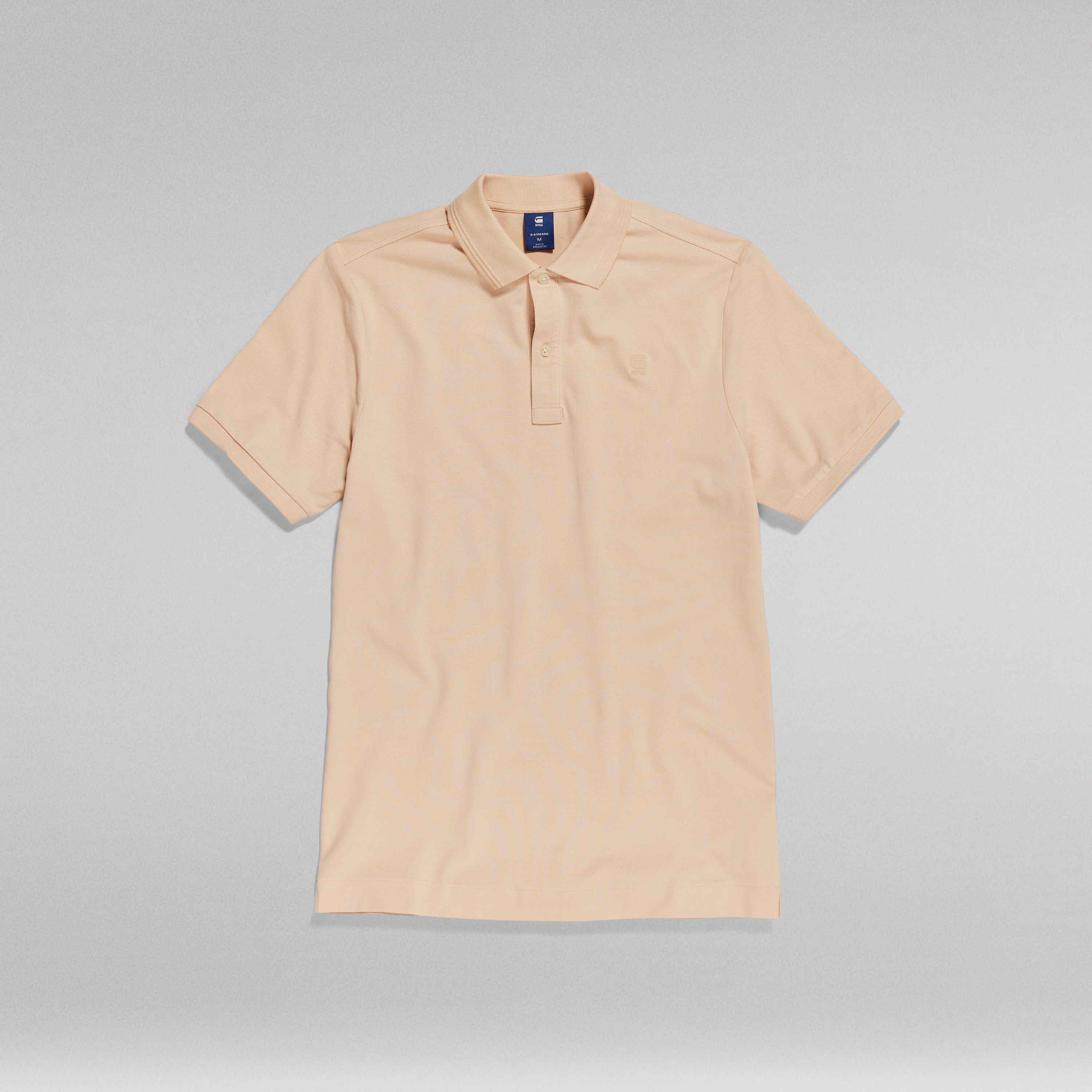 Polo Dunda Slim with ribbed collar in a light beige color, featuring a classic polo closure and short sleeves.