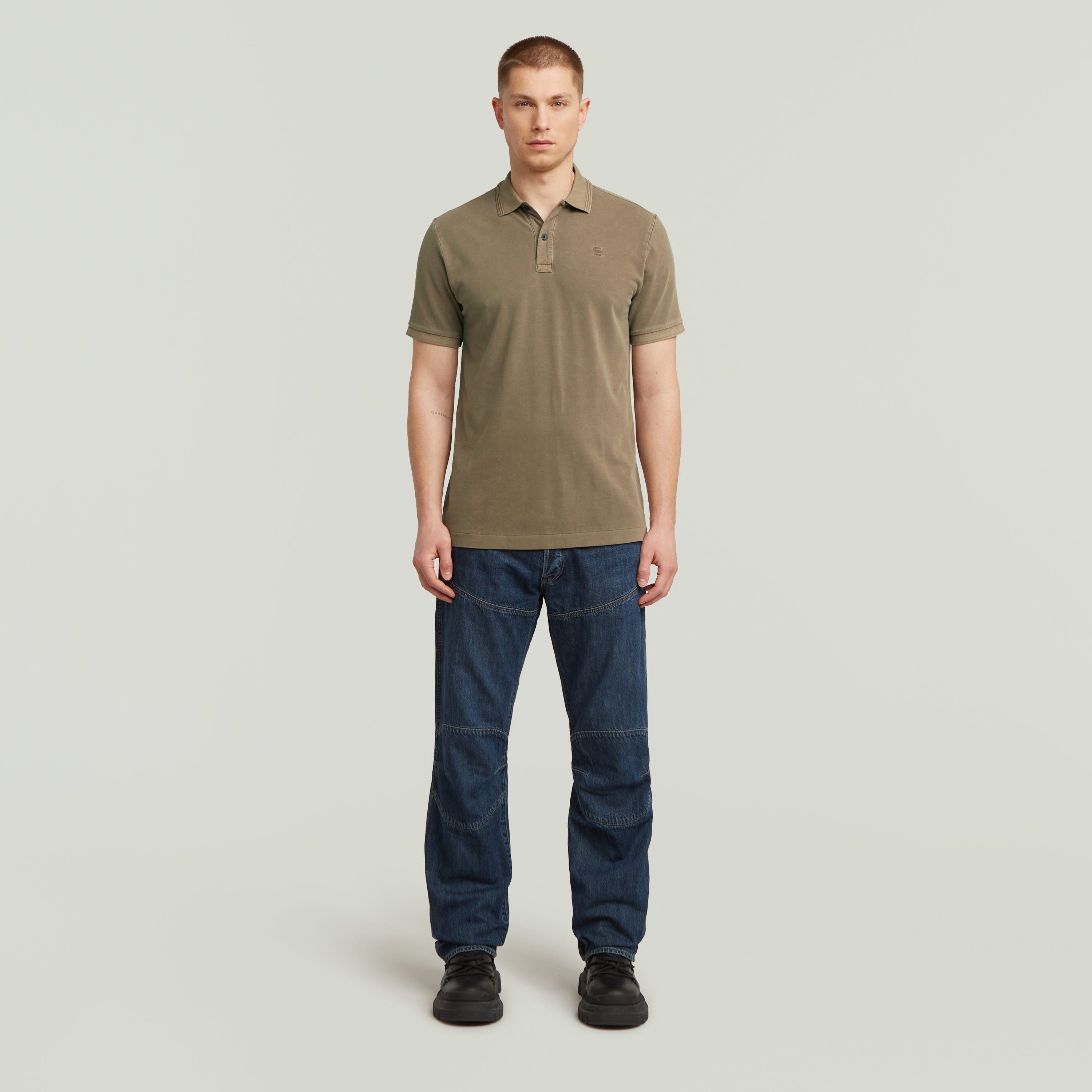 Hombre luciendo un polo Dunda Overdyed Slim fit marga corta en color marrón, ideal para un look casual y elegante.