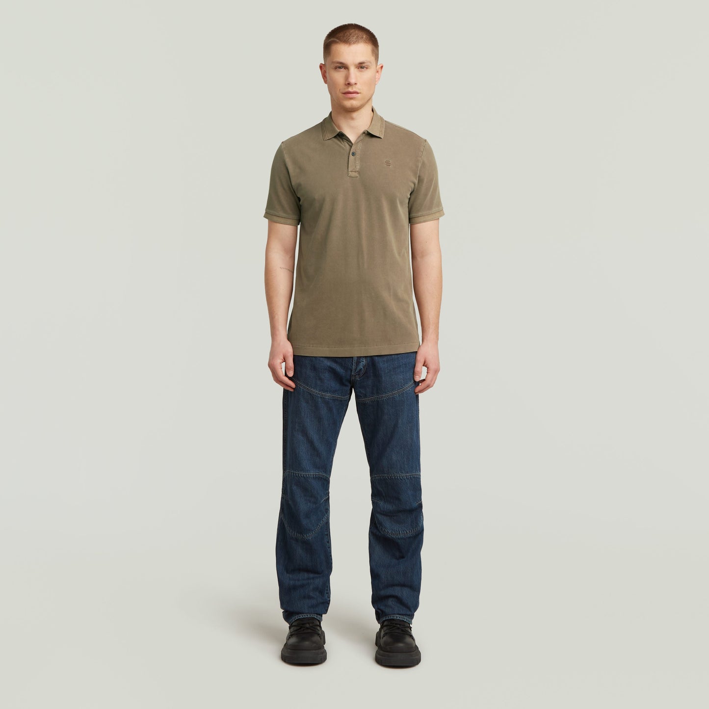 Hombre luciendo un polo Dunda Overdyed Slim fit marga corta en color marrón, ideal para un look casual y elegante.