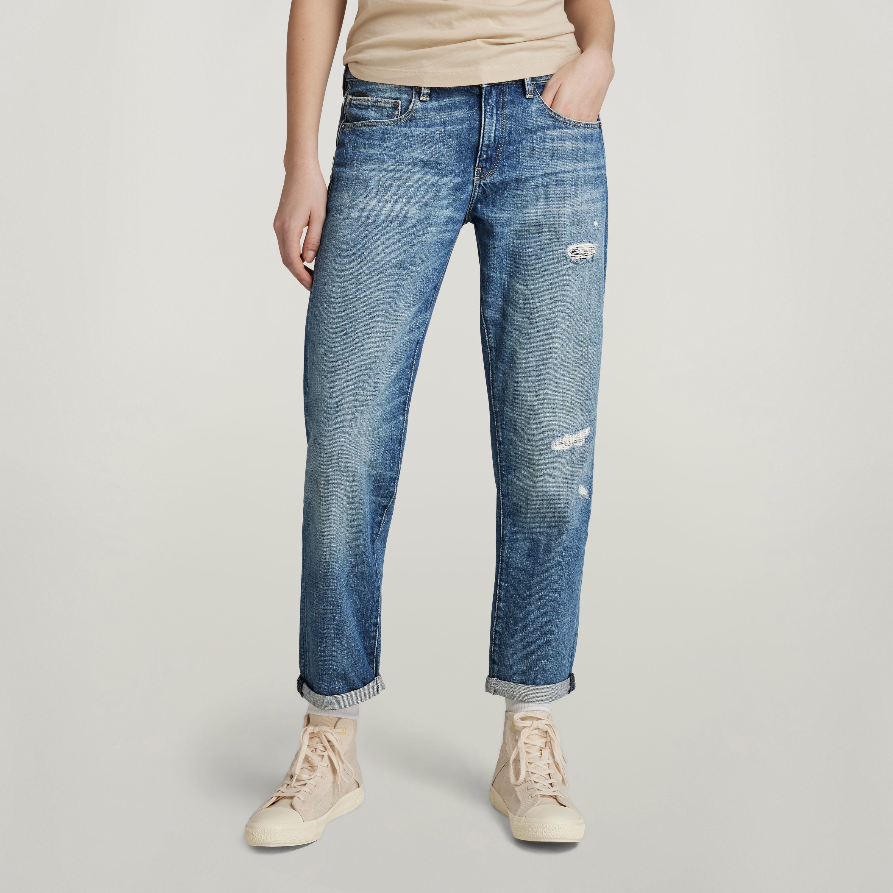 Mujer usando jeans Kate Boyfriend, corte relajado y moderno, con detalles desgastados y bajos doblados.