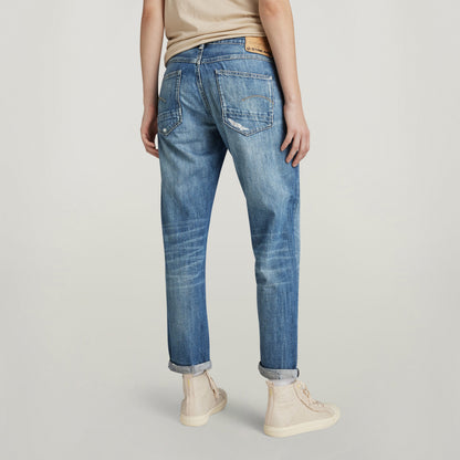 Mujer de pie mostrando los jeans Kate Boyfriend desde atrás, con un diseño relajado y ajuste cómodo.
