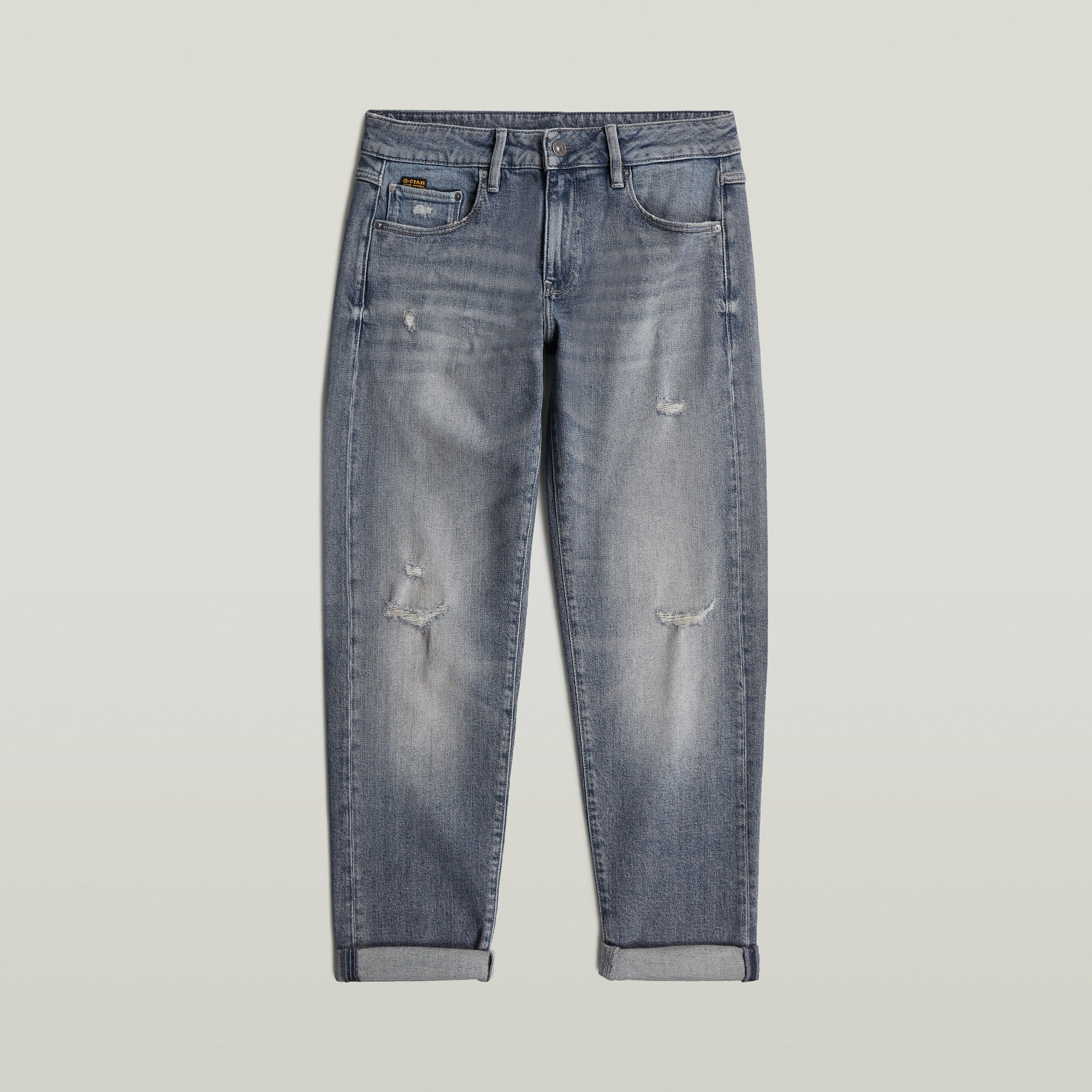 Low rise boyfriend jeans in distressed denim with relaxed fit and rolled hem.