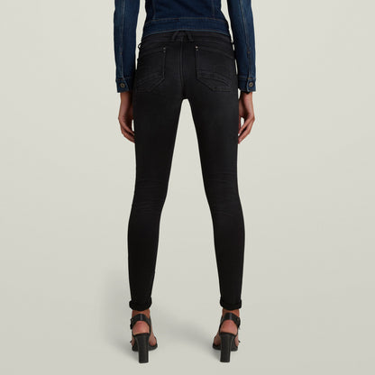 Mujer usando Jeans Lynn Super Skinny negros, vista trasera, mostrando la forma ajustada de los super skinny jeans for women.