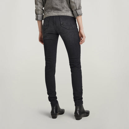 Mujer usando jeans Kafey ultra high skinny, vista trasera, con chaqueta y botas, estilo moderno.