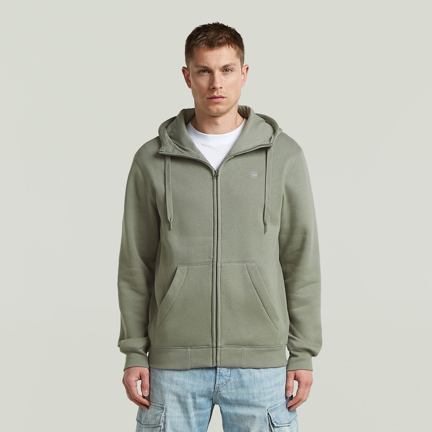 Hombre usando sudadera premium hooded zip sweatshirt en color verde con capucha y cremallera frontal.