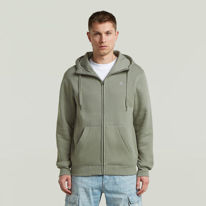 Hombre usando sudadera premium hooded zip sweatshirt en color verde con capucha y cremallera frontal.