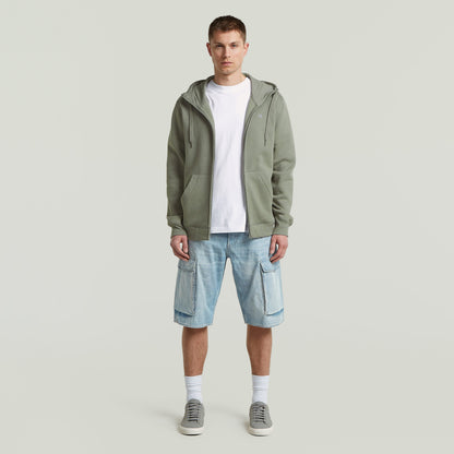 Modelo masculino usando sudadera premium hooded zip sweatshirt con pantalones cortos y zapatillas deportivas.