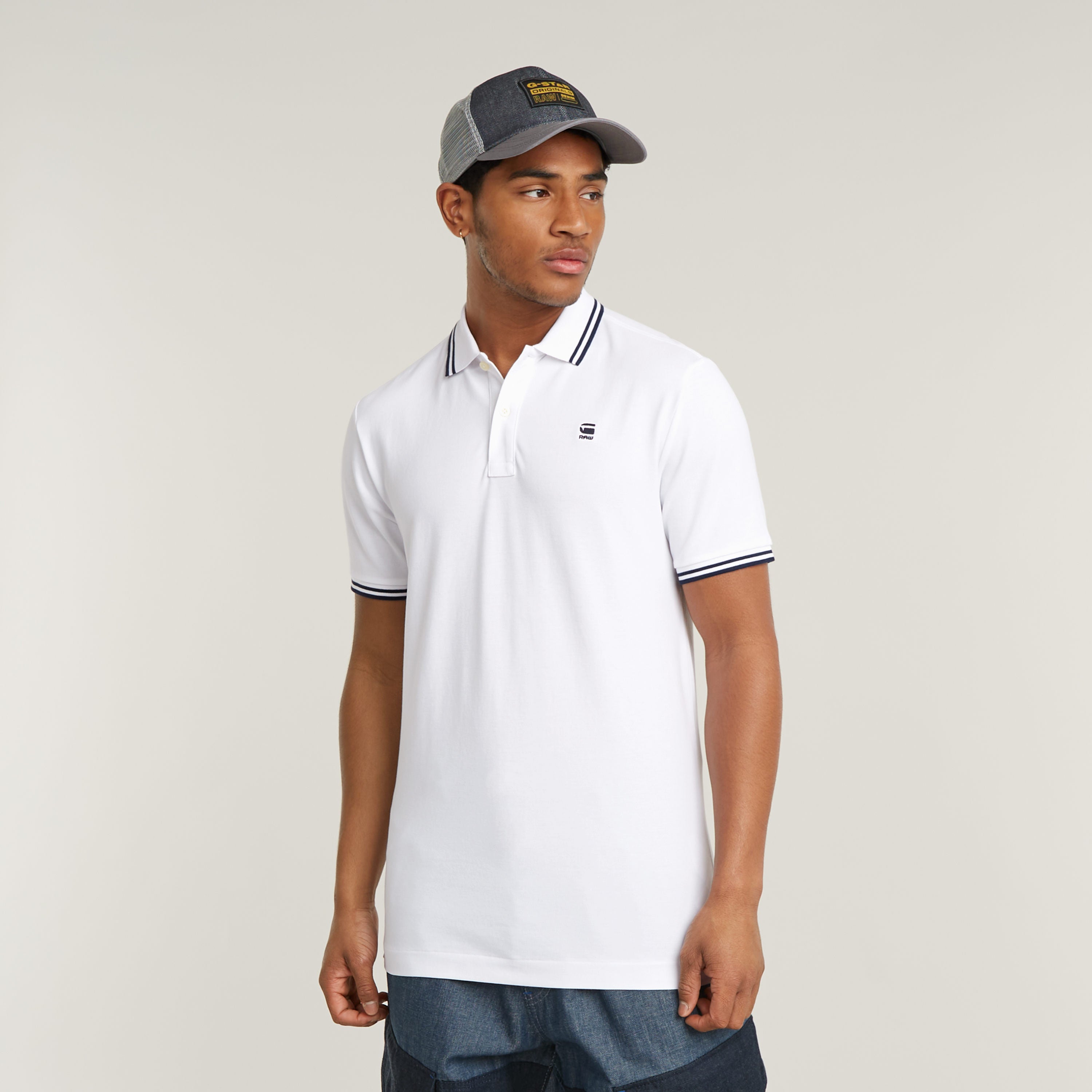 Modelo luciendo un polo Dunda Slim Stripe color blanco, parte de la colección de slim stripe polo shirt.