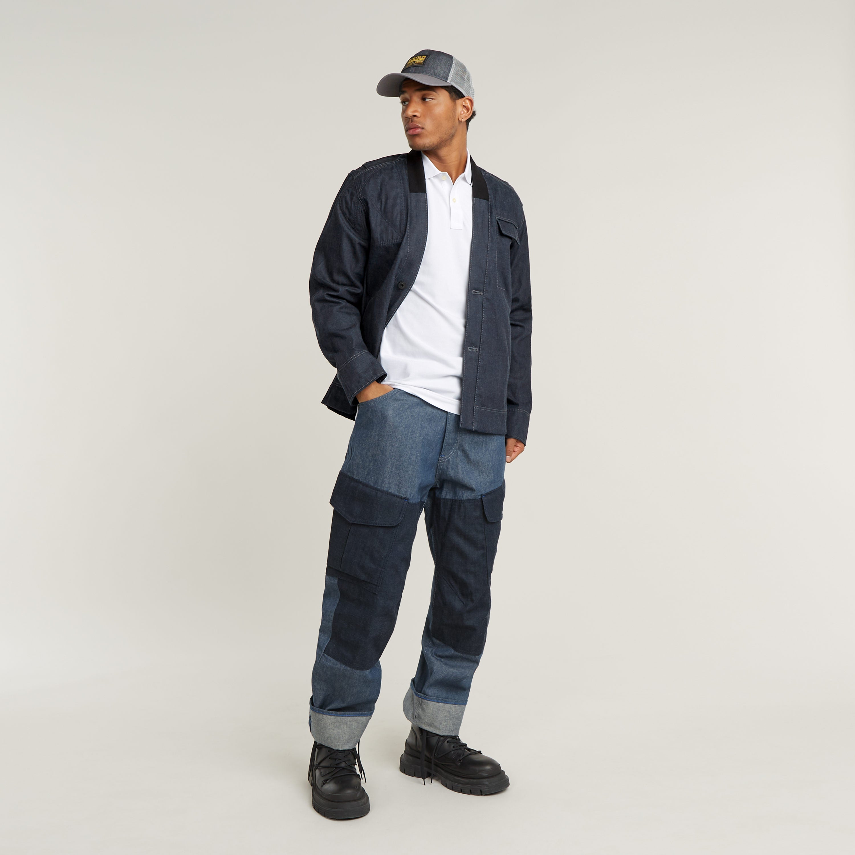 Model wearing a slim stripe polo shirt with denim pants and cap, showcasing casual style and comfort.