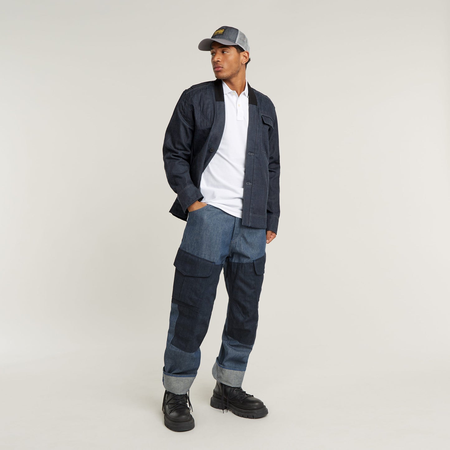 Model wearing a slim stripe polo shirt with denim pants and cap, showcasing casual style and comfort.