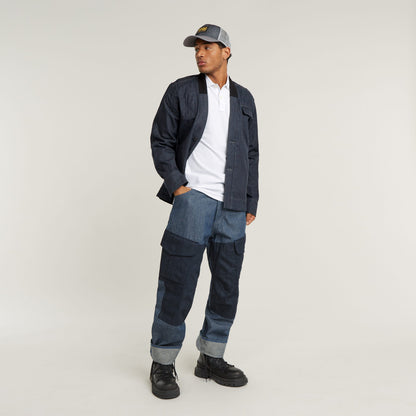 Model wearing a slim stripe polo shirt with denim pants and cap, showcasing casual style and comfort.