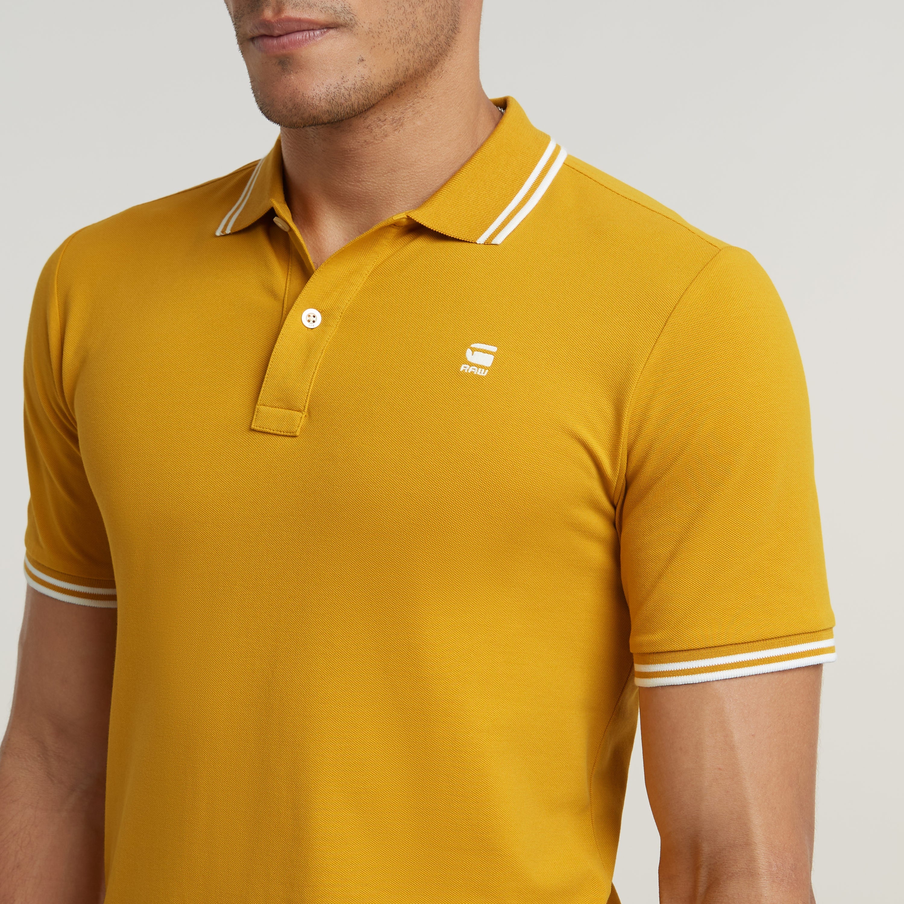 Polo Dunda Slim Stripe en color amarillo mostaza con cuello y puños a rayas, ajuste slim stripe polo shirt.