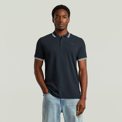 Modelo luciendo una camiseta polo slim stripe con diseño clásico en color azul oscuro y detalles en el cuello.