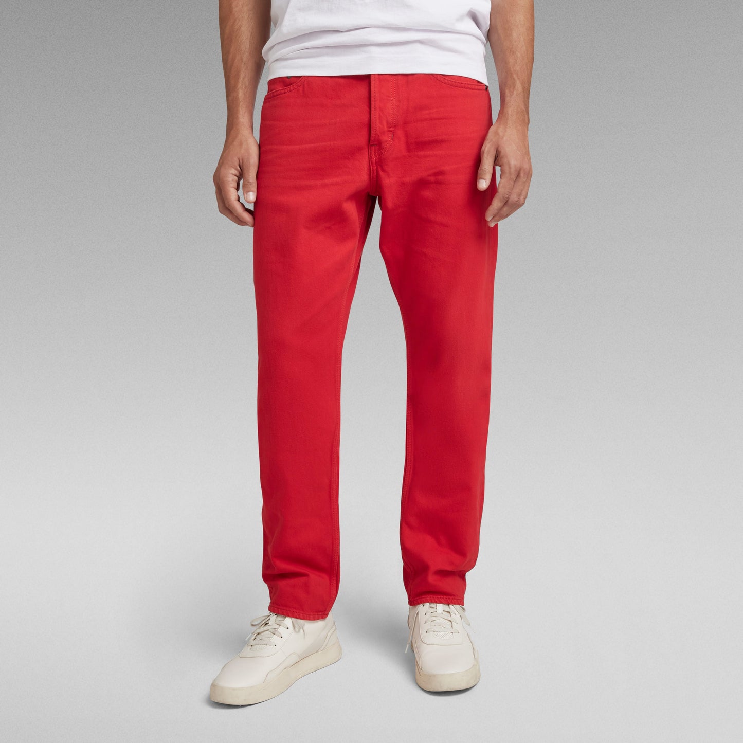 Modelo vistiendo jeans Triple A regular straight en color rojo, con corte innovador y atemporal.