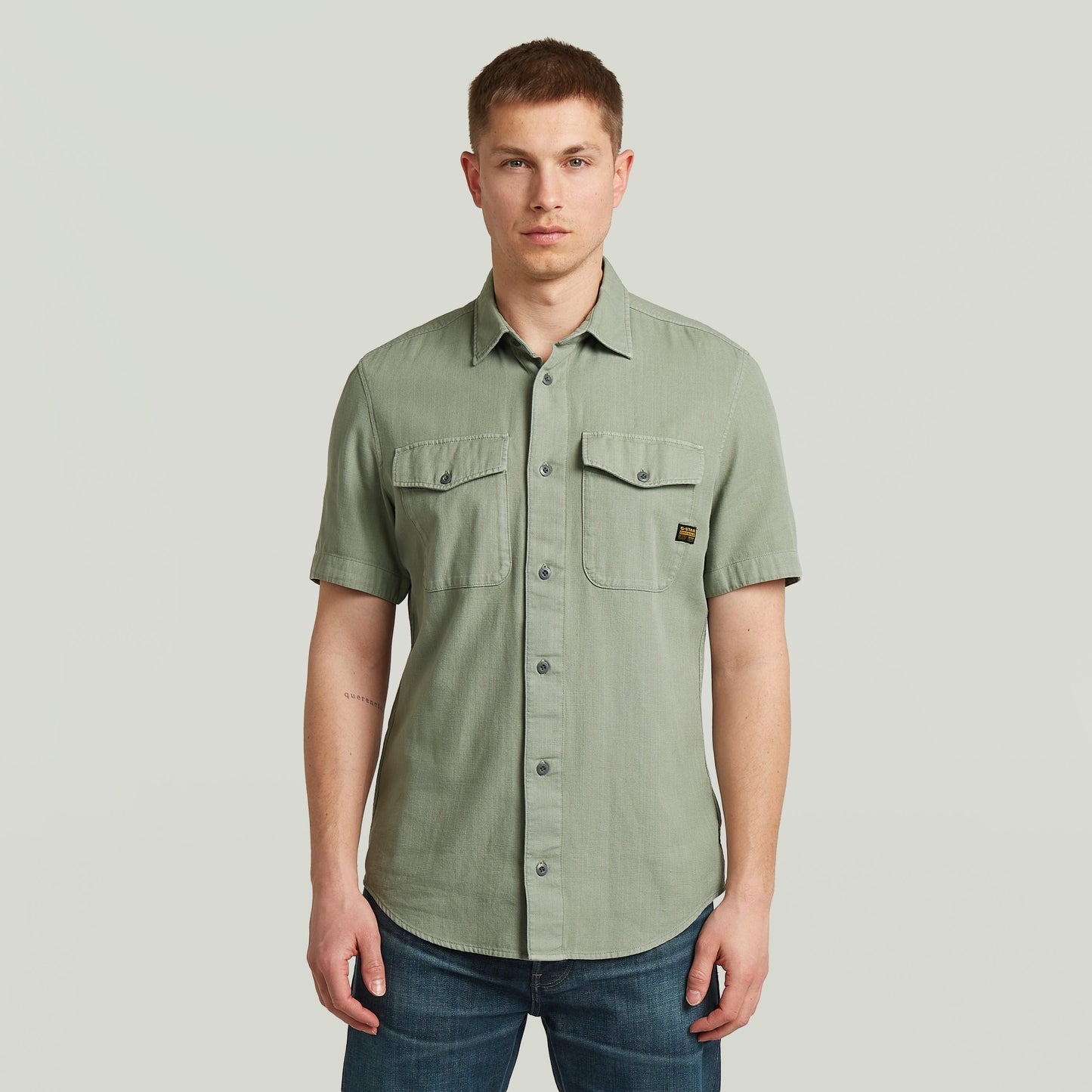 Modelo masculino vistiendo una camisa marine slim fit shirt de color verde con corte ajustado y bolsillos en el pecho.