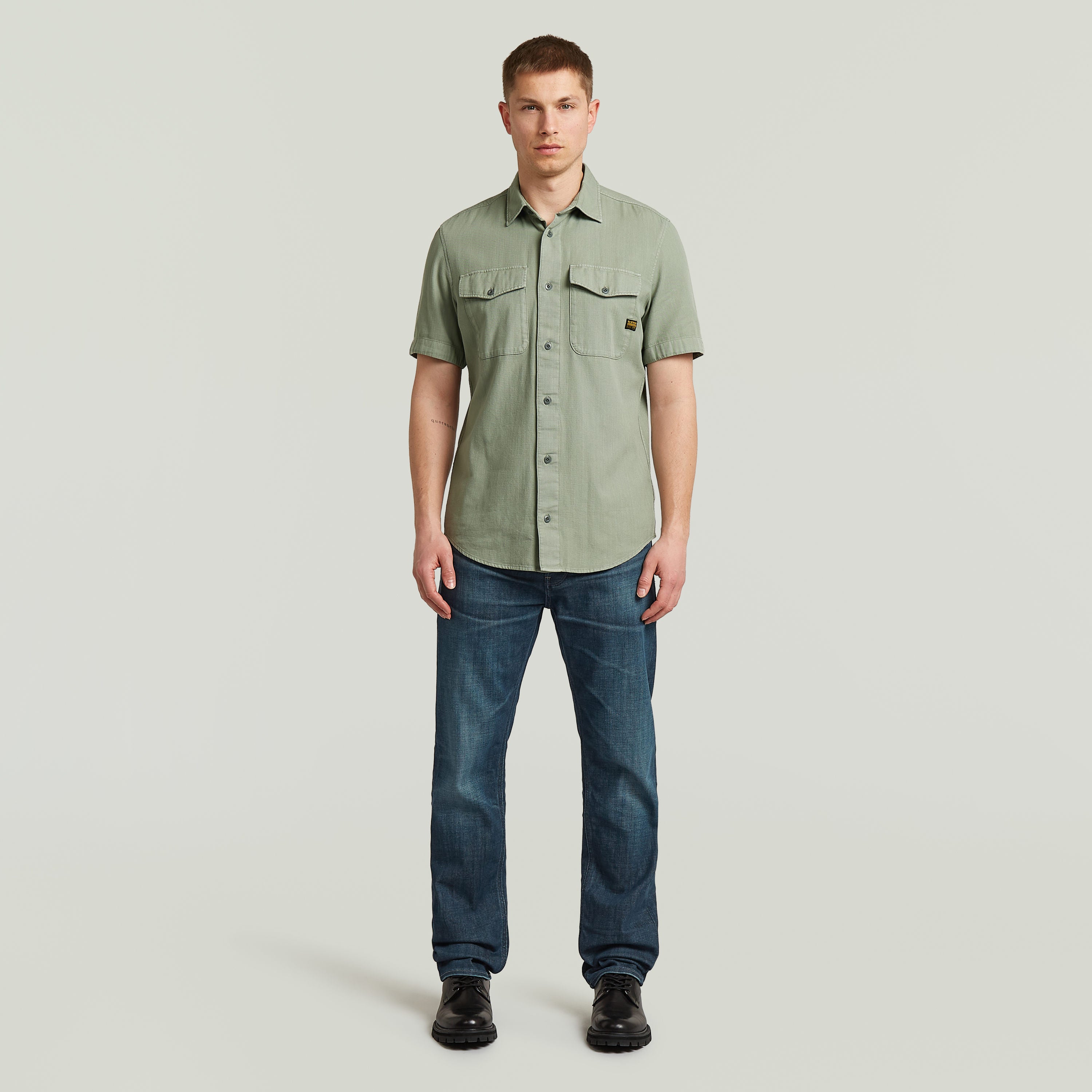 Hombre usando una camisa marine slim fit shirt verde con corte ajustado y bolsillos en el pecho.