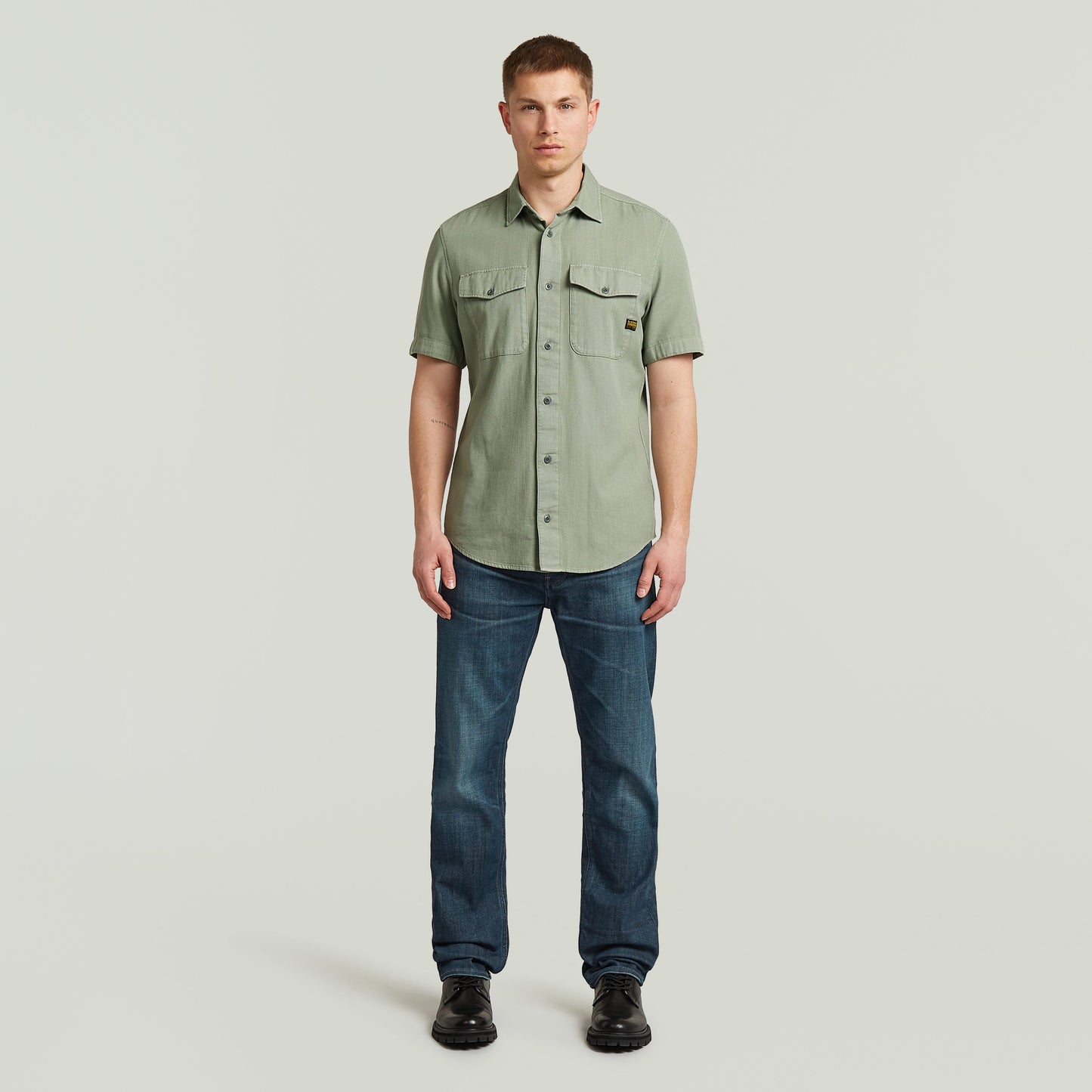 Hombre usando una camisa marine slim fit shirt verde con corte ajustado y bolsillos en el pecho.