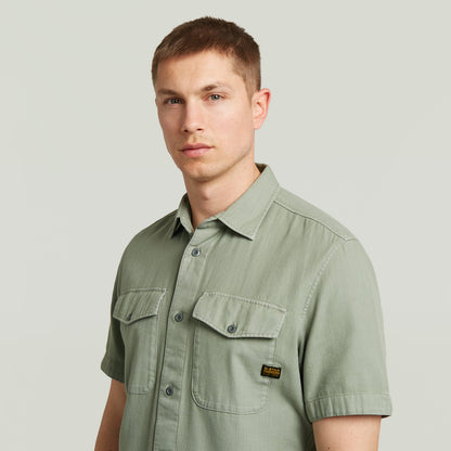 Hombre usando una camisa Marine Slim fit shirt verde con bolsillos en el pecho y cierre de botones.