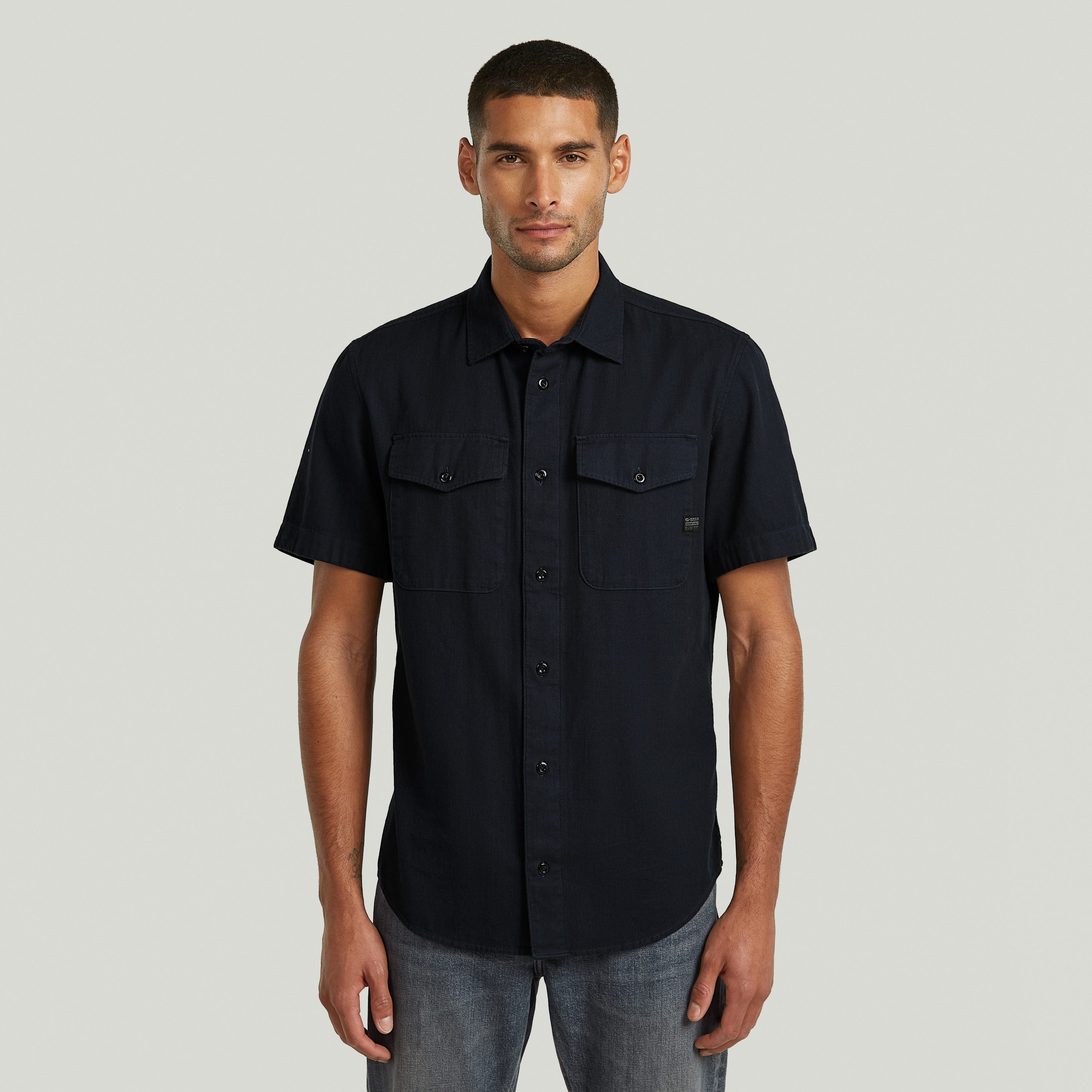 Camisa Marine slim azul con corte ajustado, cuello de camisa y bolsillos con solapa en el pecho.