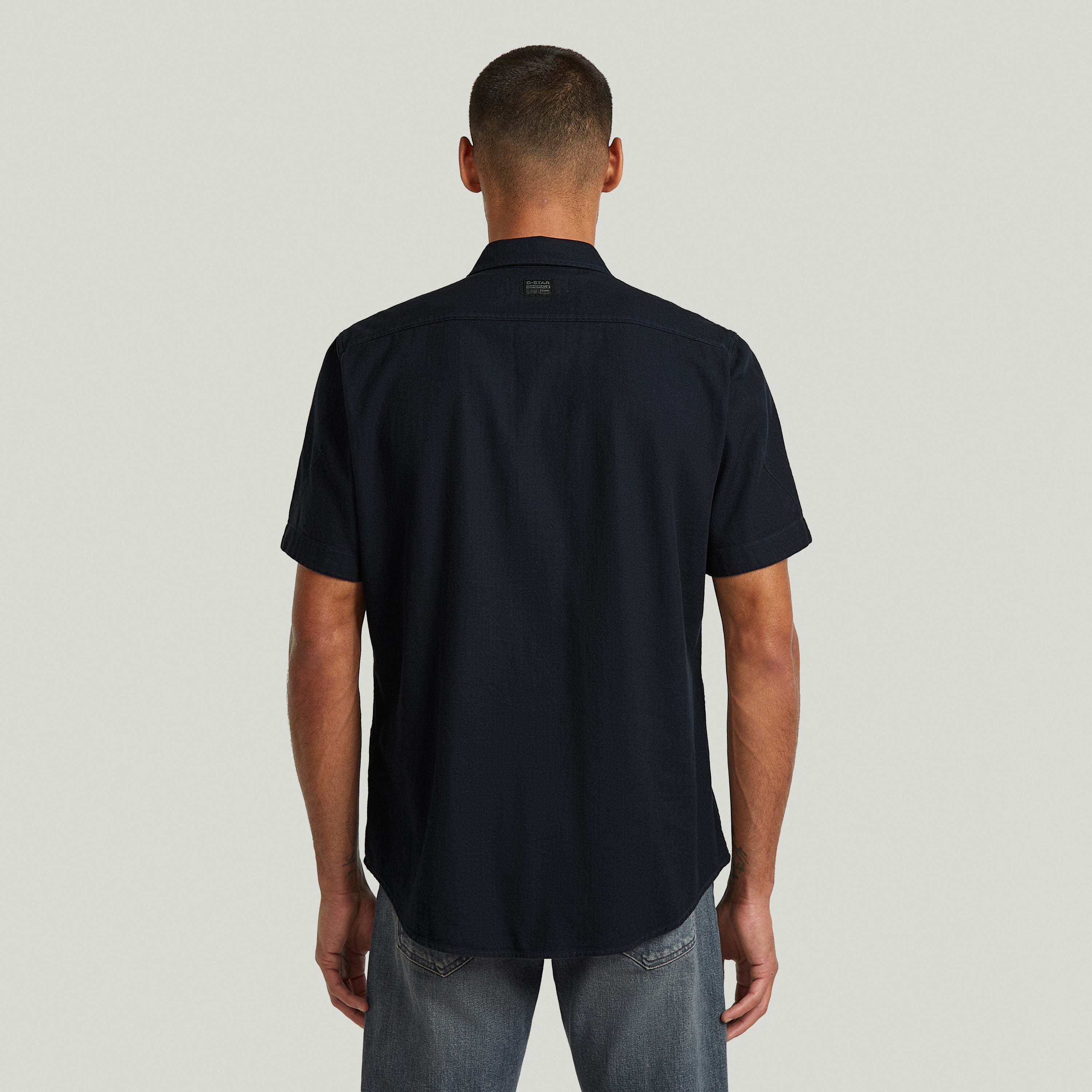 Vista trasera de la camisa Marine slim azul, con corte ajustado y cuello de camisa, color azul oscuro.