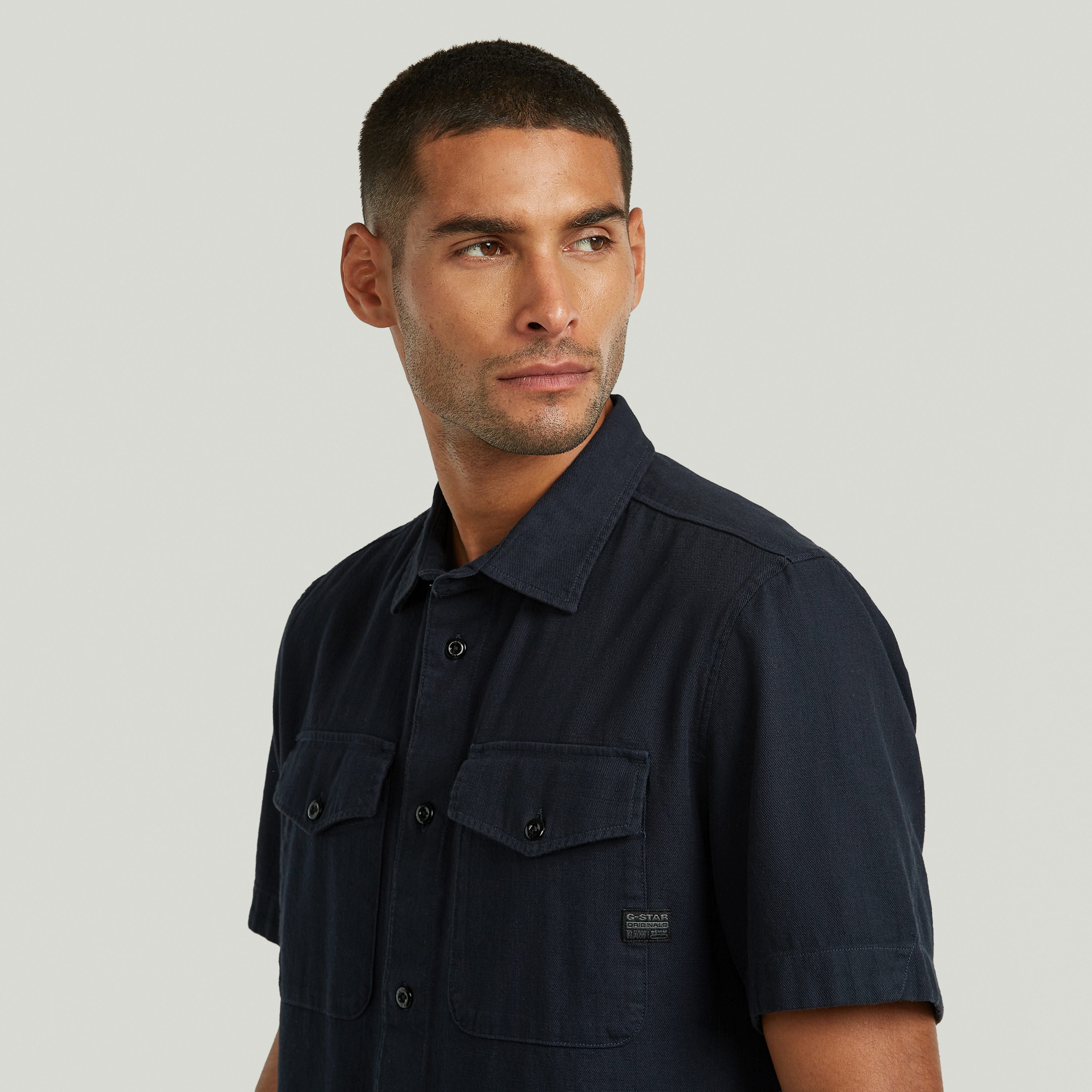 Modelo usando la camisa Marine slim azul con corte ajustado y bolsillos en el pecho.