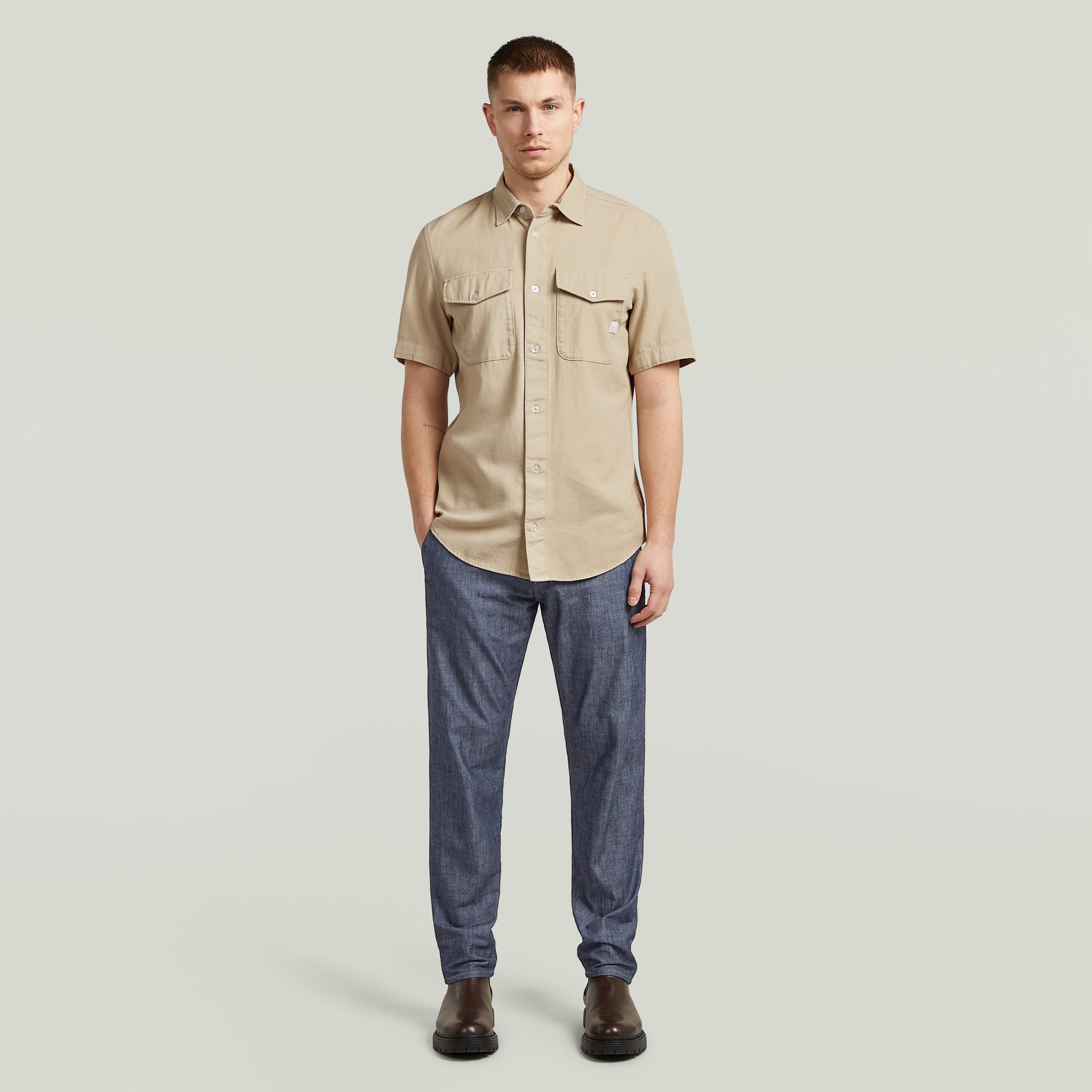 Camisa Marine Slim Fit en color beige con corte ajustado y bolsillos en el pecho, modelando estilo moderno.