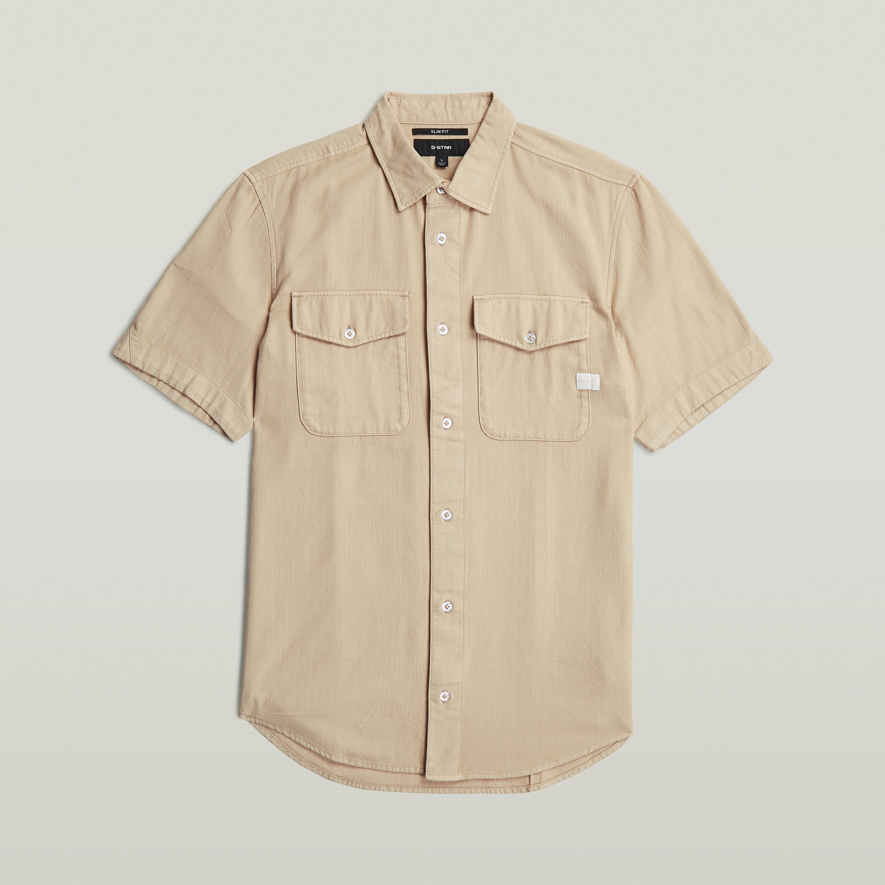Camisa Marine Slim fit color beige con corte ajustado, bolsillos con solapa y cuello de camisa.