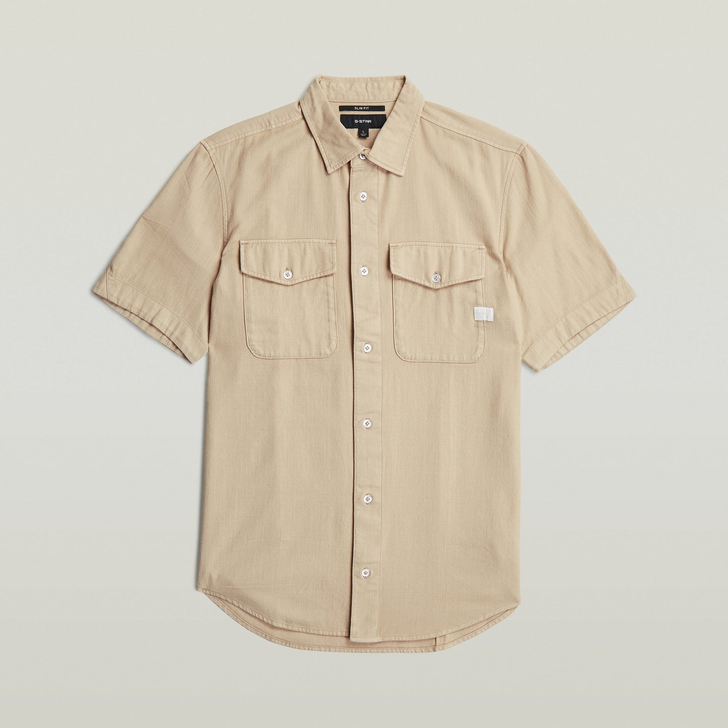 Camisa Marine Slim fit color beige con corte ajustado, bolsillos con solapa y cuello de camisa.