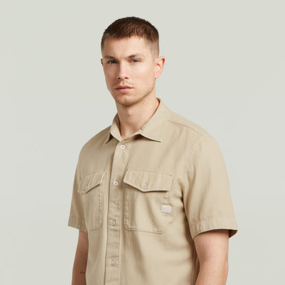 Camisa Marine Slim fit beige con corte ajustado y bolsillos en el pecho, modelado por un hombre.