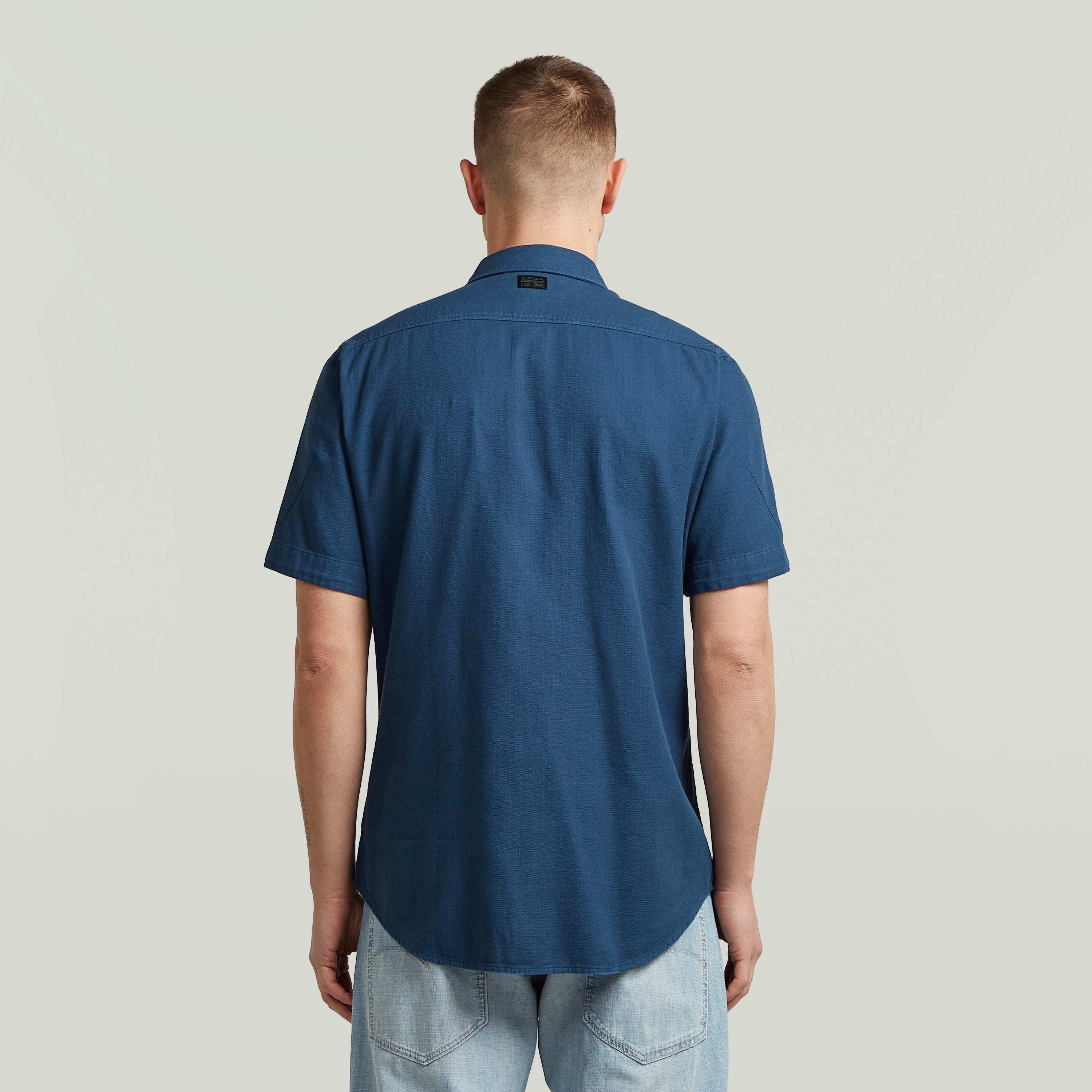 Camisa Marine Slim azul vista trasera, corte ajustado y bajo redondeado, color azul intermedio.