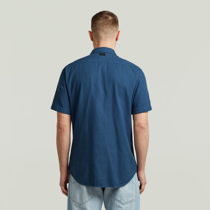 Camisa Marine Slim azul vista trasera, corte ajustado y bajo redondeado, color azul intermedio.