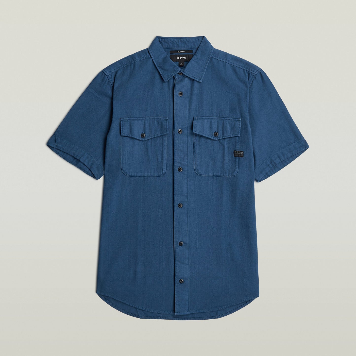 Camisa Marine Slim azul con corte ajustado, botones y bolsillos en el pecho, color azul intermedio.