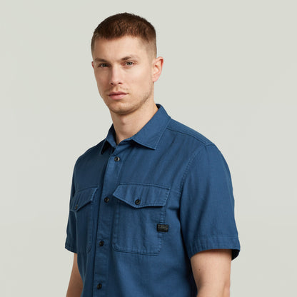 Camisa Marine Slim azul en modelo masculino con corte ajustado y bolsillos en el pecho.