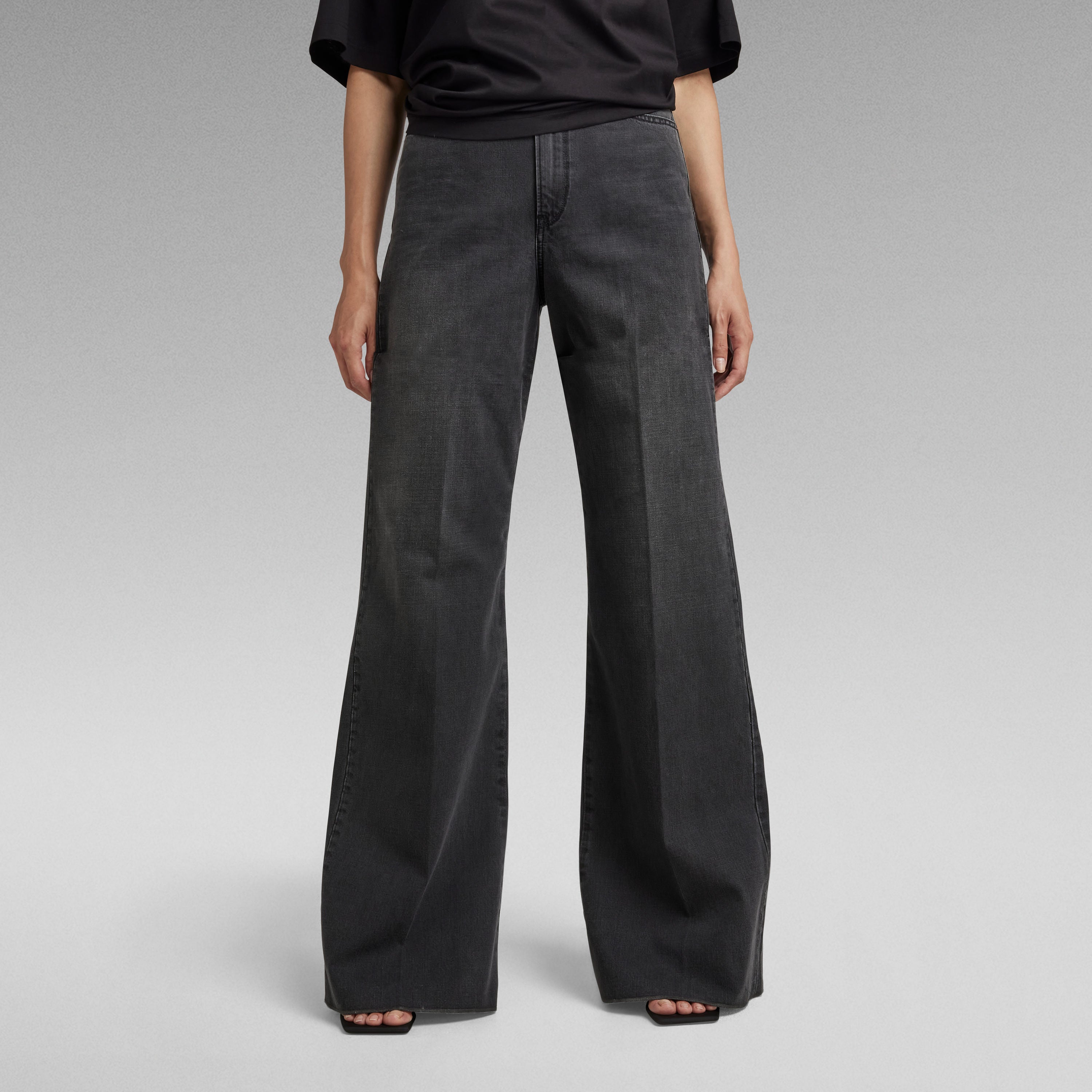 Mujer usando jeans Deck ultra high wide leg en color negro, con pernera ancha y ajuste ceñido en la cintura.