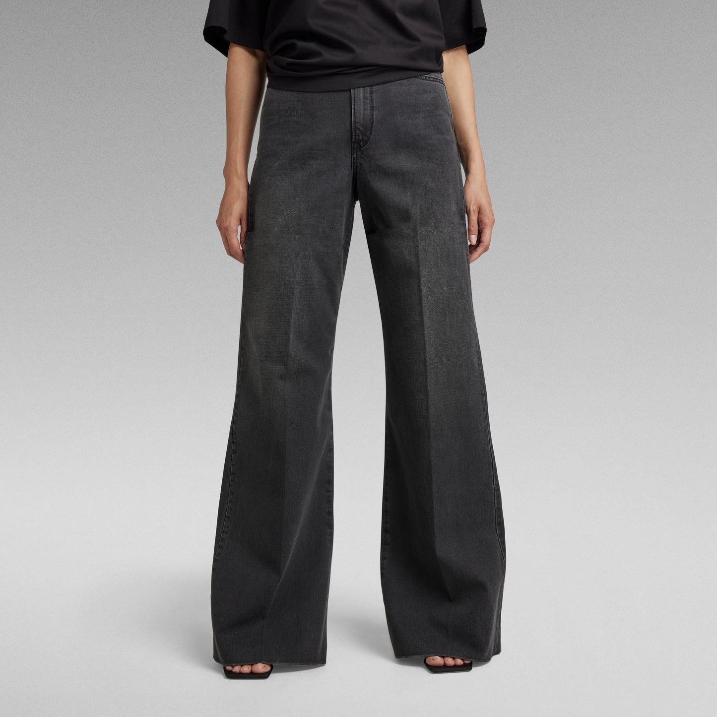 Mujer usando jeans Deck ultra high wide leg en color negro, con pernera ancha y ajuste ceñido en la cintura.