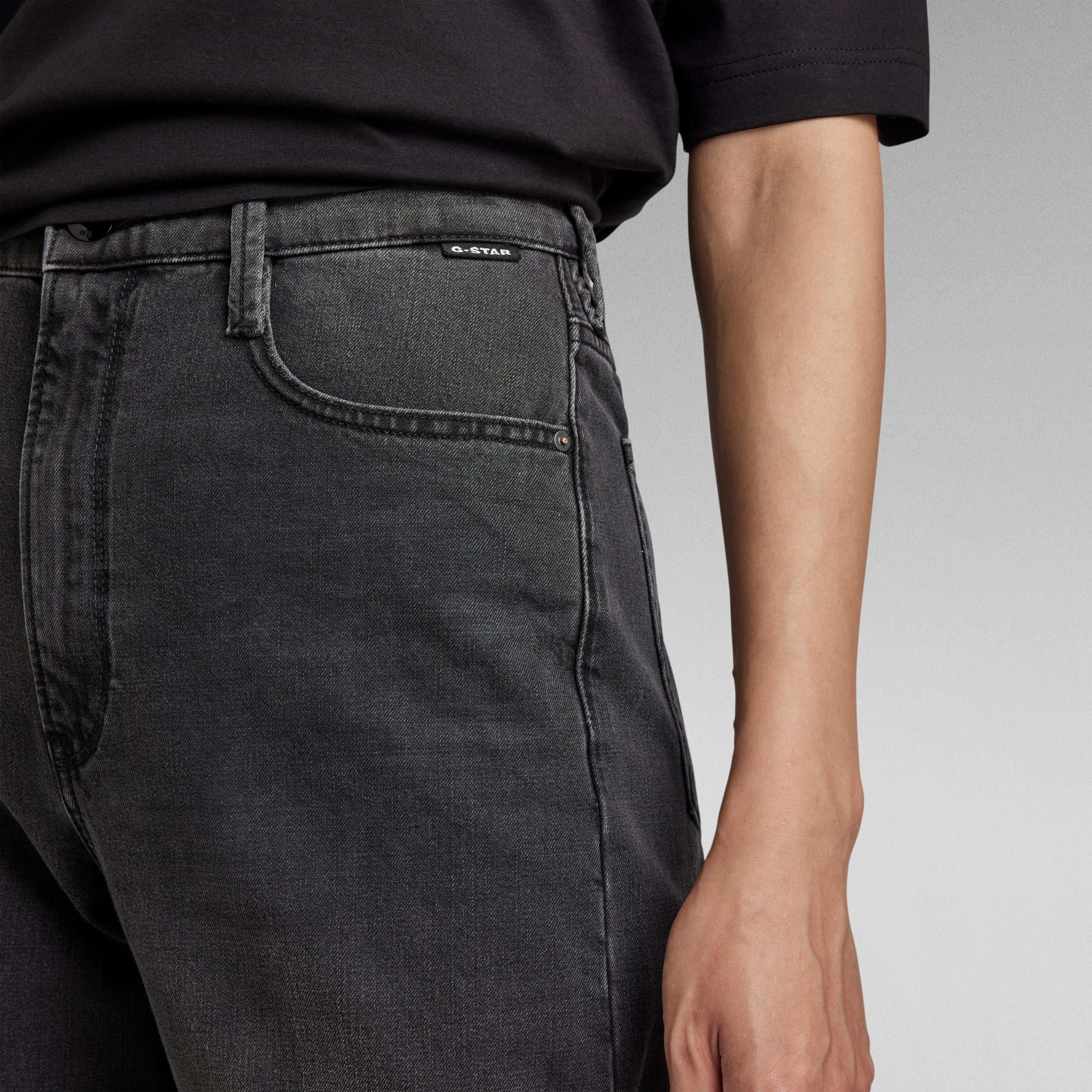 Detalle de los jeans Deck ultra high wide leg jeans en color negro con ajuste ceñido en la cintura y pernera amplia.