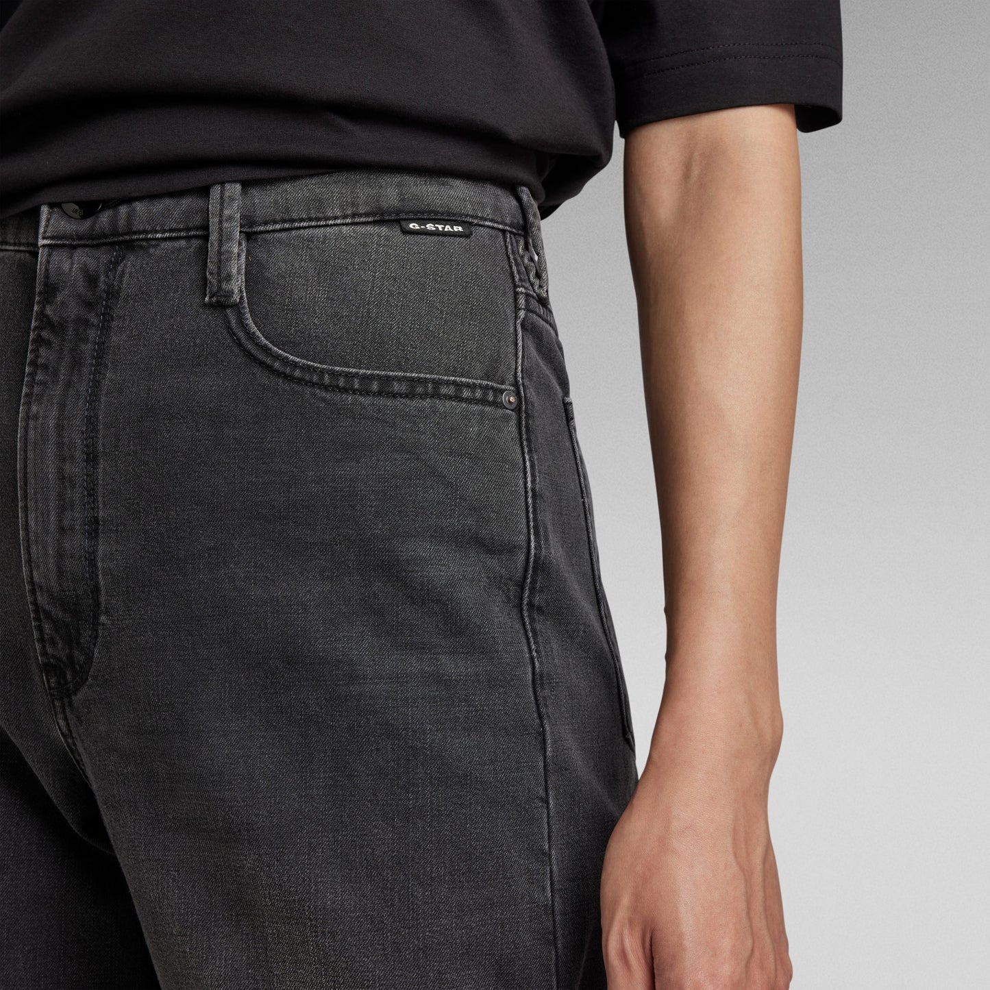 Detalle de los jeans Deck ultra high wide leg jeans en color negro con ajuste ceñido en la cintura y pernera amplia.