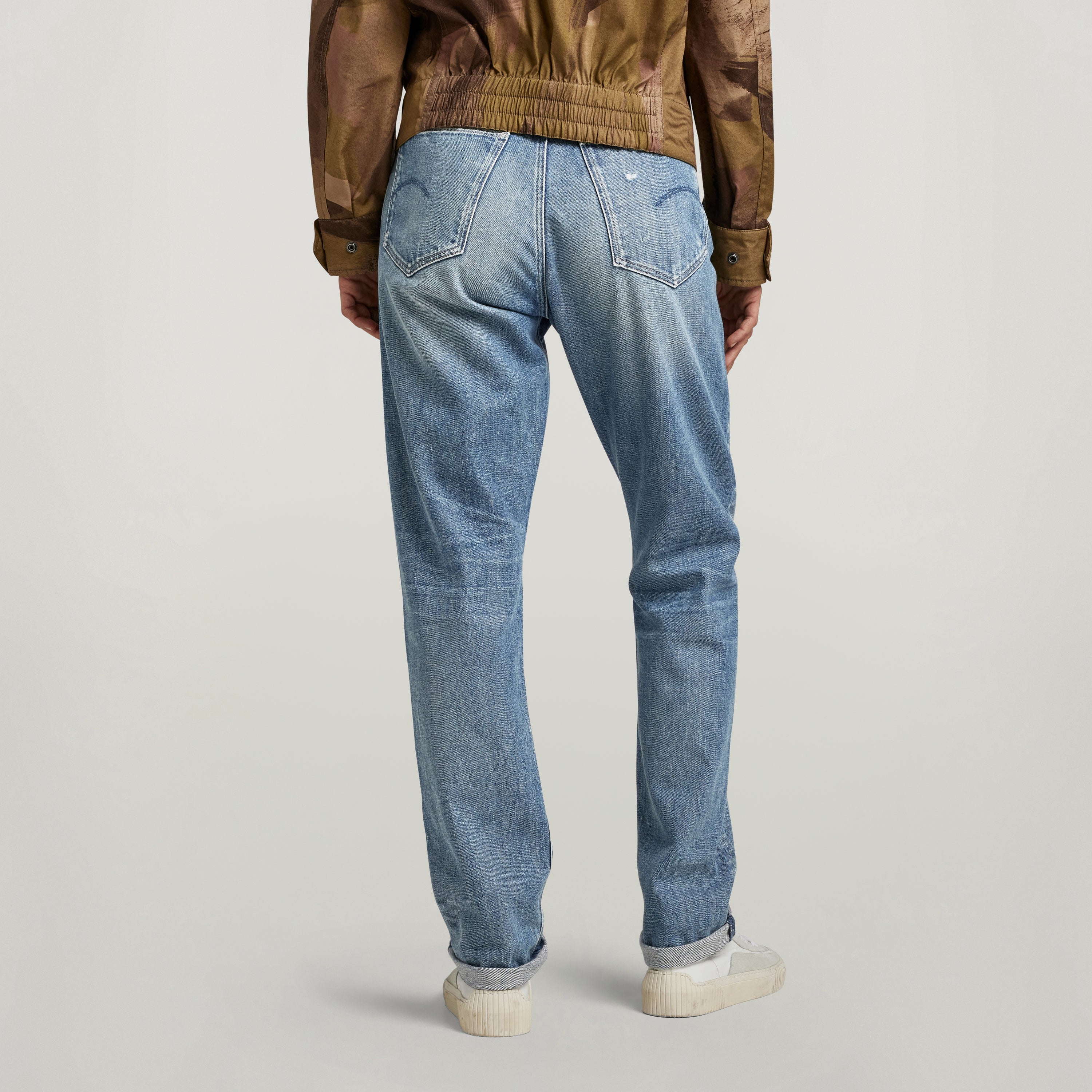 High-waisted slim jeans viewed from the back, showcasing the fitted design and light wash color.