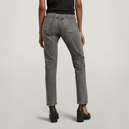 Mujer usando jeans Virjinya Slim de tiro alto y pernera ajustada, vista trasera en un fondo claro, alta moda.