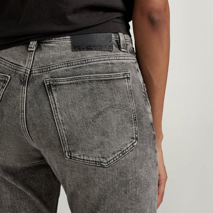 Detail of high-waisted slim jeans showing back pockets and denim texture